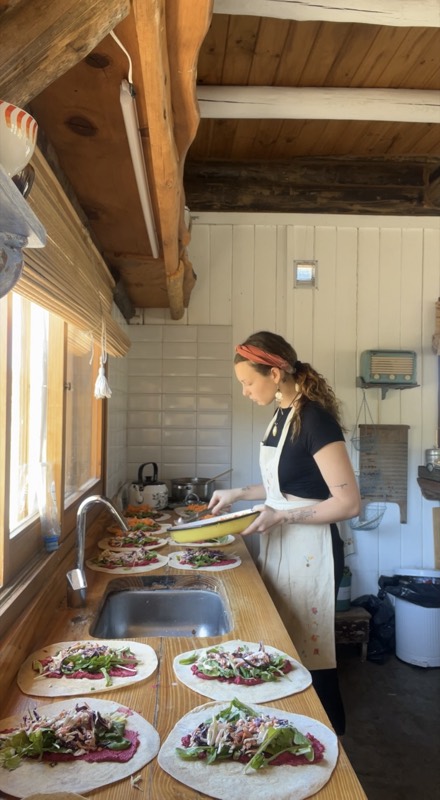 Memi emplatando wraps en la cocina de un retiro.