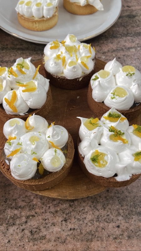 Tartitas con merengue sobre una tabla.