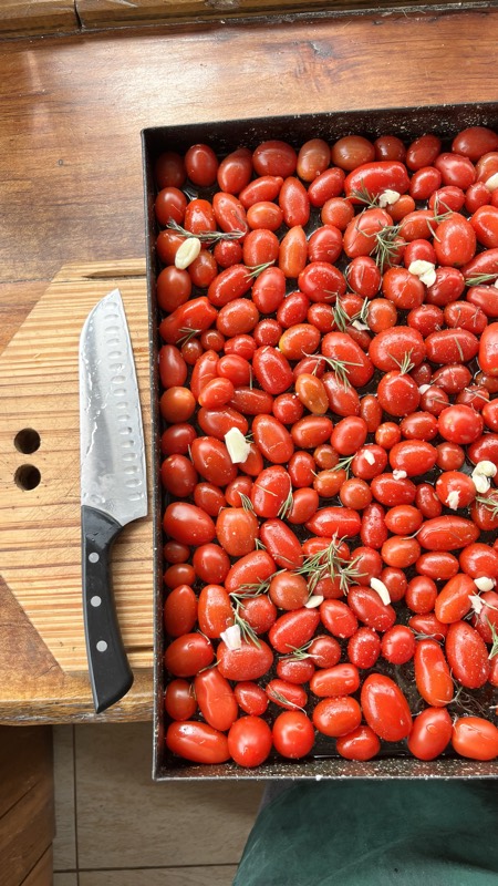 Una fuente llena de tomates cherry listos para el horno.